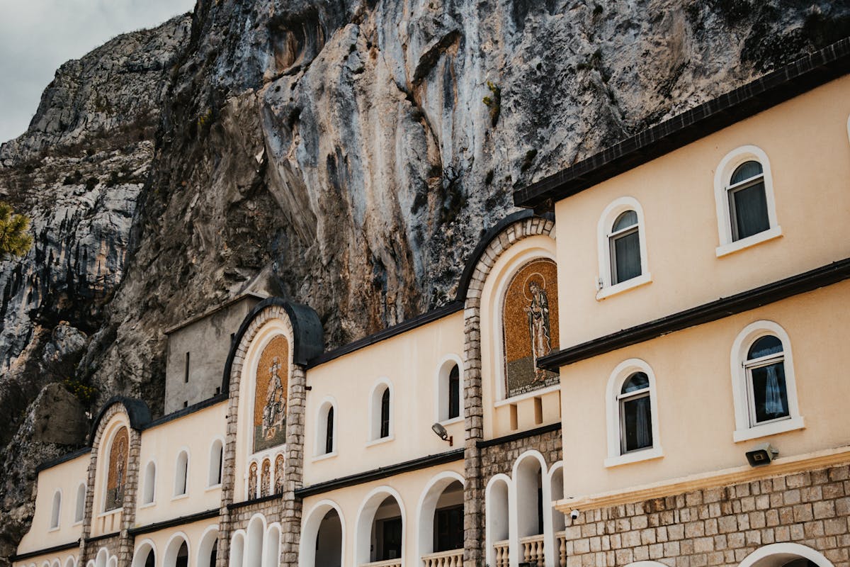 Savina Monastery framed by cypress trees with the bay visible below